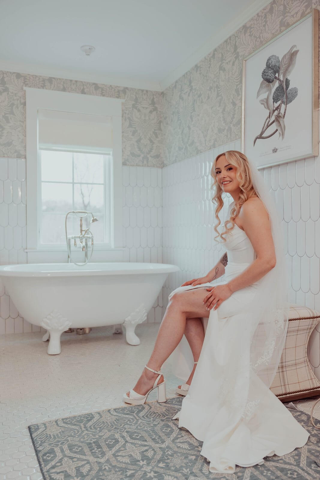 Bride seated in the Milea Estate Vineyard bridal suite with a clawfoot tub and tile