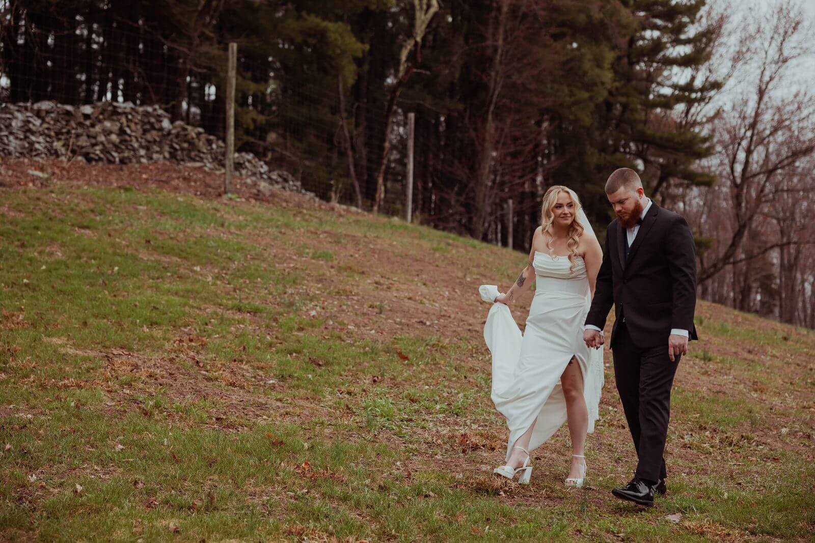 Bride and groom walking hand in hand across the vineyard grounds at Milea Estate Vineyard in the Hudson Valley