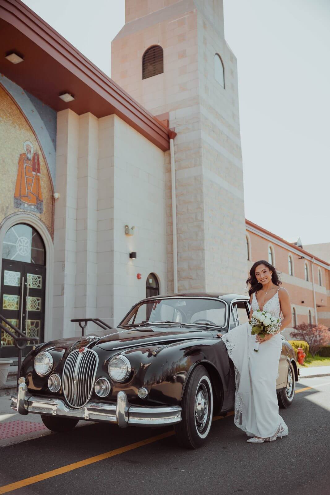 Bride beside a vintage black Jaguar in front of St. Mina Coptic Orthodox Church, Holmdel NJ